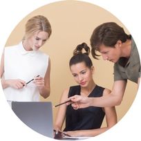 two ladies and a gentleman looking at a content on laptop