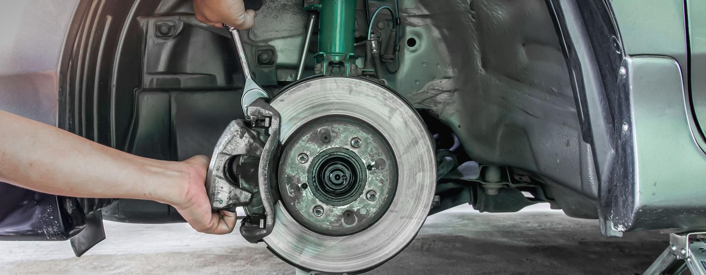 Ein Mechaniker wechselt eine Autobremse aus