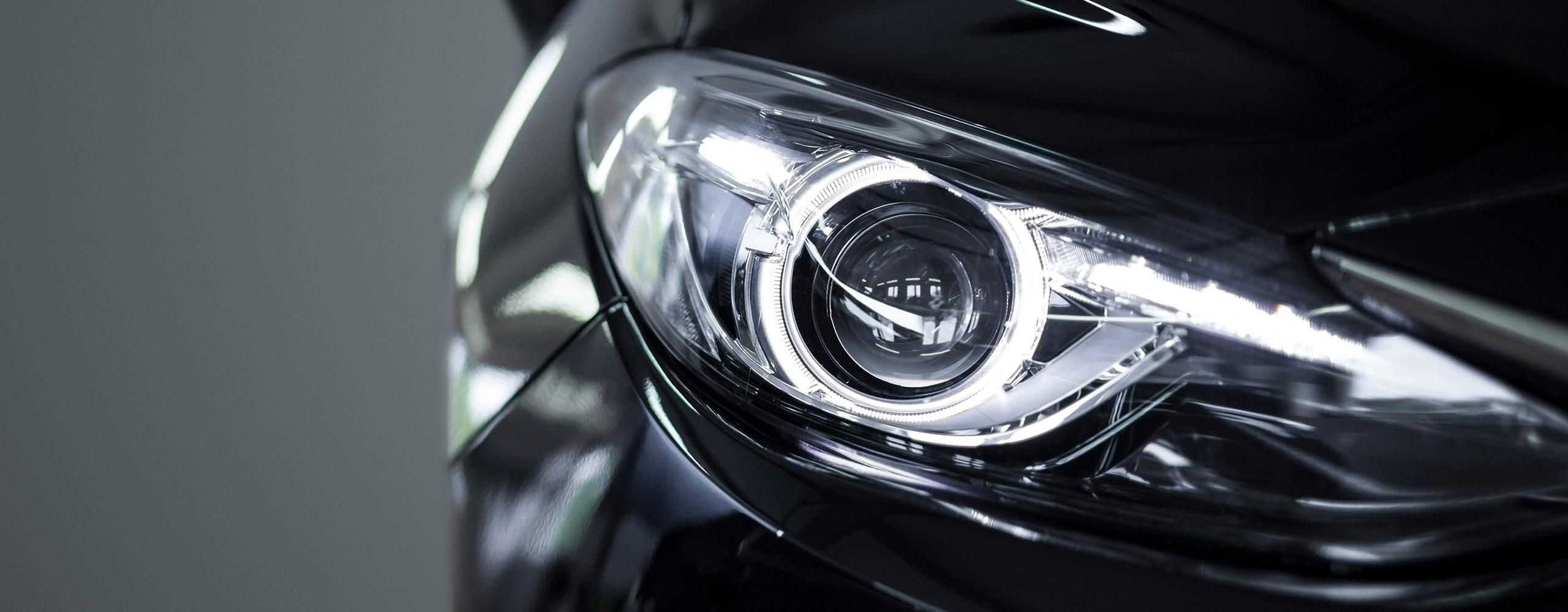 Nahaufnahme eines hellen LED-Scheinwerfers in einem schwarzen Auto