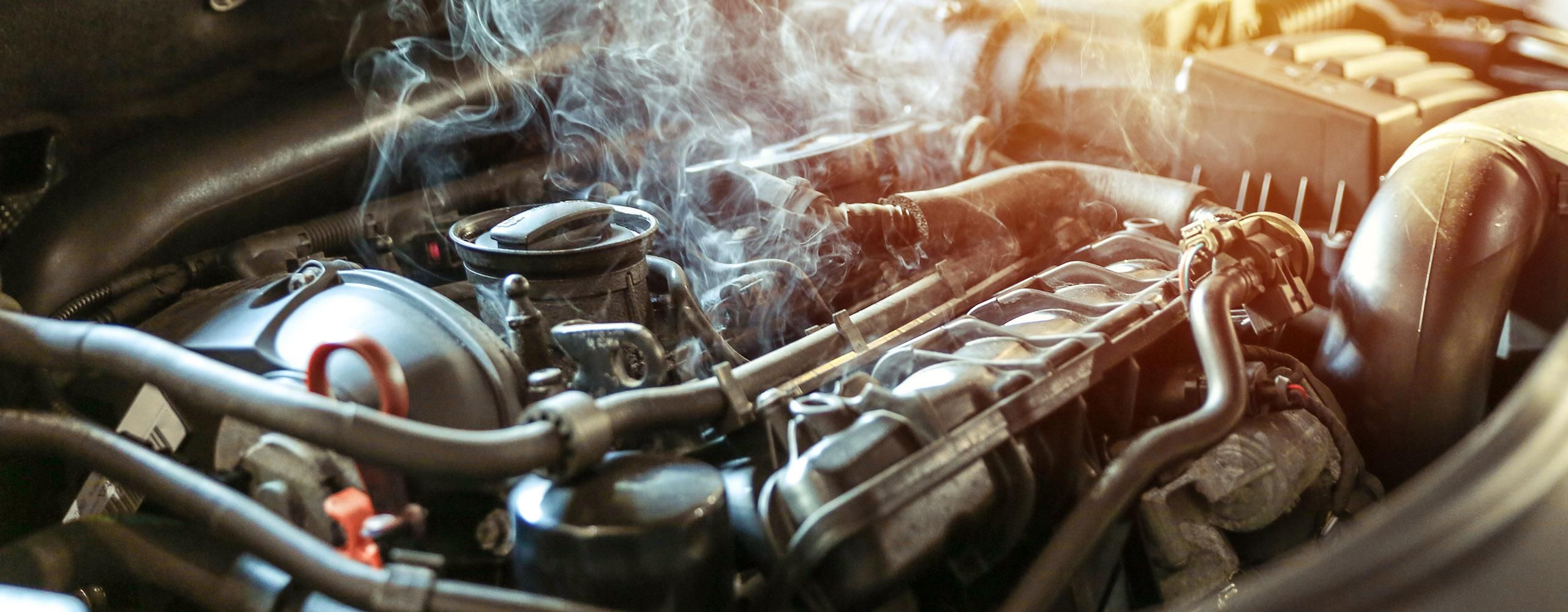 Der qualmende Motor eines Fahrzeugs bei geöffneter Motorhaube