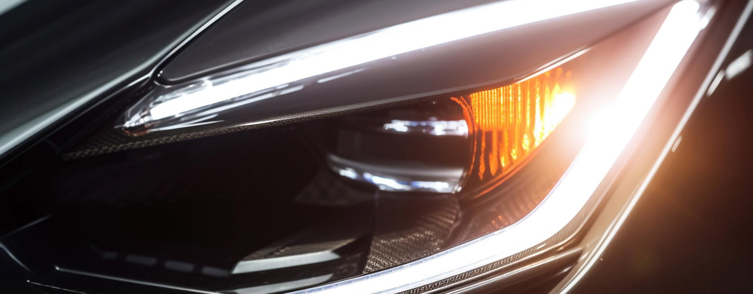 LED-Scheinwerfer nachrüsten: Nahaufnahme des linken Scheinwerfers eines weißen Fahrzeugs