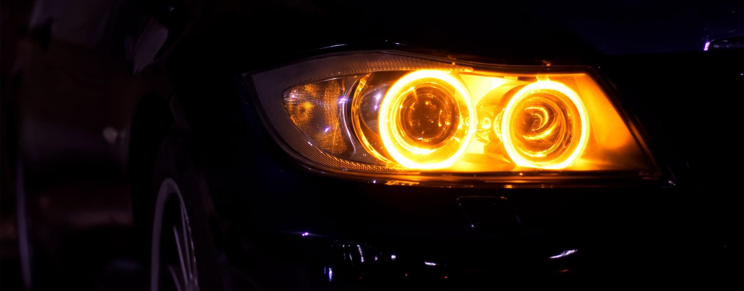 Der rechte vordere Scheinwerfer eines Autos leuchtet gelb.