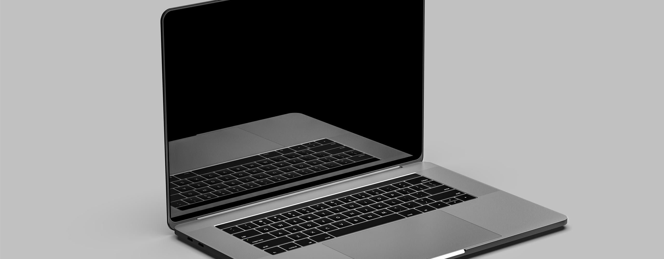 Ein MacBook steht aufgeklappt auf einer hellgrauen Oberfläche. Das Display ist schwarz.